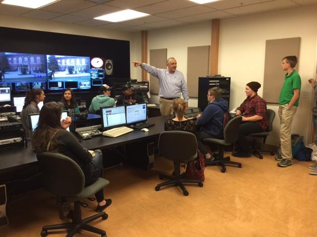 Journalism professor Ray Eckness works with Montana high school students as they assemble a live broadcast on April 14.